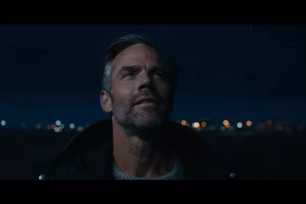 Een man staart in de verte, het is nacht.
