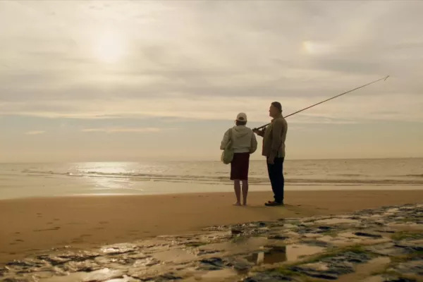 Visser en vrouw aan het strand van Oostende.