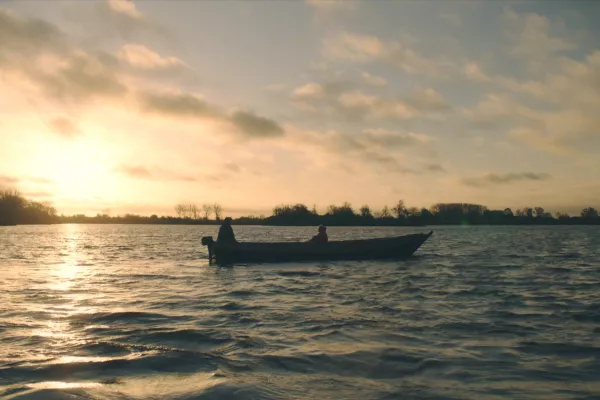 Bootje op een meer bij zonsondergang.