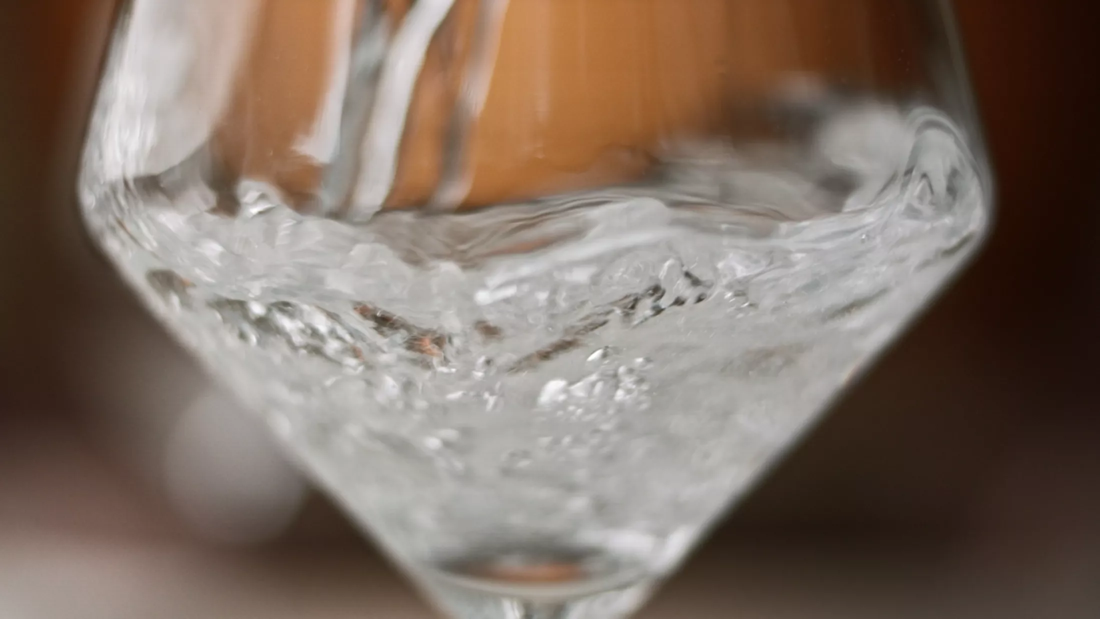 Een glas water wordt gevuld.