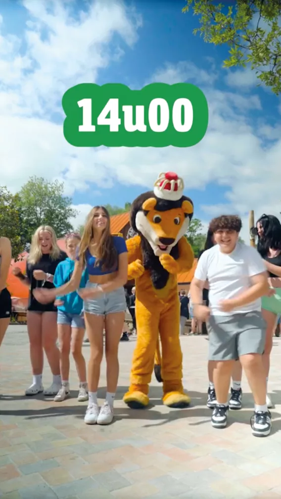 De leeuw van Bellewaerde danst met enkele kinderen.