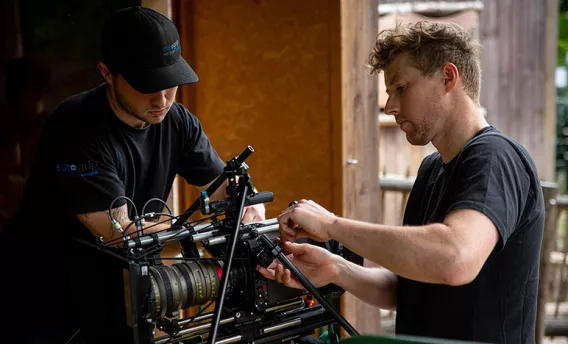 Twee crewleden aan de camera.