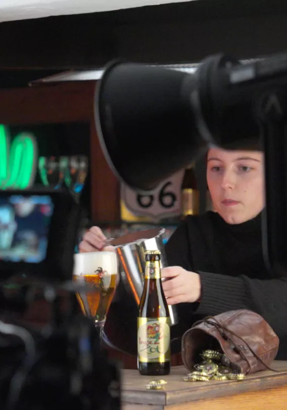 Een dame zorgt voor het schuim van een Brugse Zot.